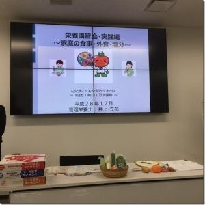 モニターに栄養講習の資料が映し出されている写真